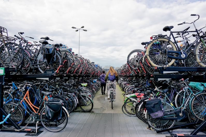 Bike-friendly Cities - a person riding a bike through a large amount of bikes