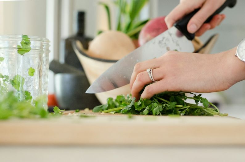 Sustainable Kitchen - person cutting vegetables with knife