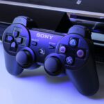 Gaming Consoles - black Sony PS2 controller on white surface