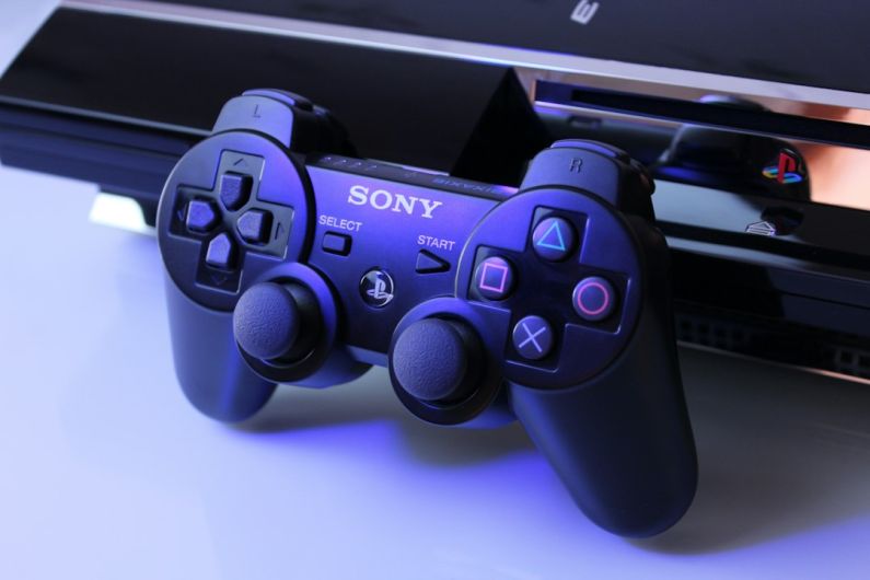 Gaming Consoles - black Sony PS2 controller on white surface