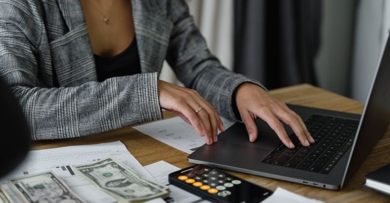 Cash Flow Management - A Woman in Plaid Blazer Using Her Laptop